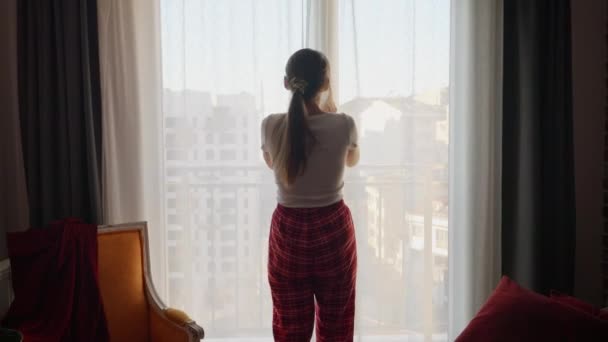 Widok Tyłu Kobiety Piżamie Idącej Dużego Okna Salonie Otwierające Zasłony — Wideo stockowe