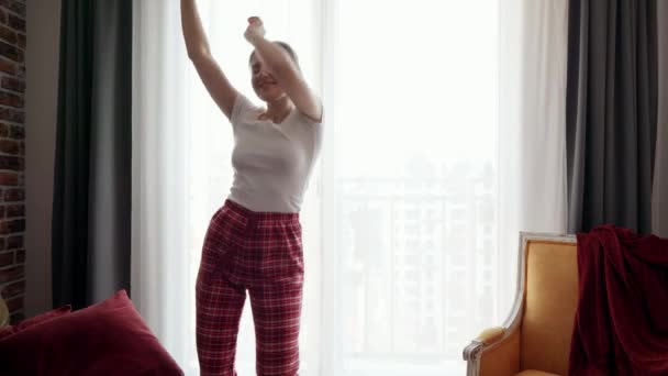 Szczęśliwa Uśmiechnięta Kobieta Słuchająca Muzyki Tańcząca Piżamie Przy Oknie Ludzie — Wideo stockowe