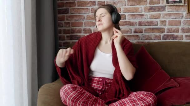 Wanita Muda Duduk Sofa Dan Menari Sambil Mendengarkan Musik Headphone — Stok Video