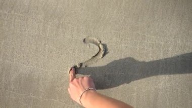 2024 yılını deniz sahilindeki ıslak kumda yazan genç kadının yakın çekimi..