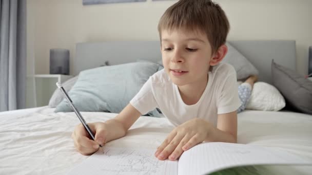 Jeune Garçon Pyjama Écrivant Dans Cahier Alors Était Allongé Lit — Video
