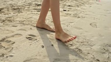 Küçük çocuğun ayaklarıyla deniz suyu ısısını ölçtüğü yakın plan. Tatil, tatil, doğada hafta sonu.