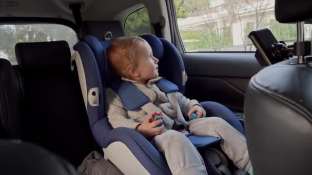 Pequeno Bebê Sentando Cadeira Segurança Infantil Olhando Para Fora Janela — Vídeo de Stock