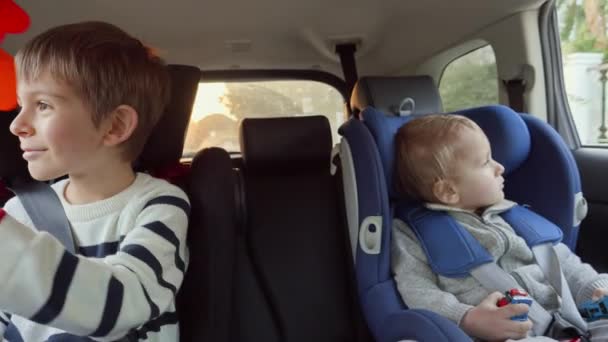 Deux Enfants Souriants Heureux Assis Sur Rangée Arrière Voiture Regardant — Video