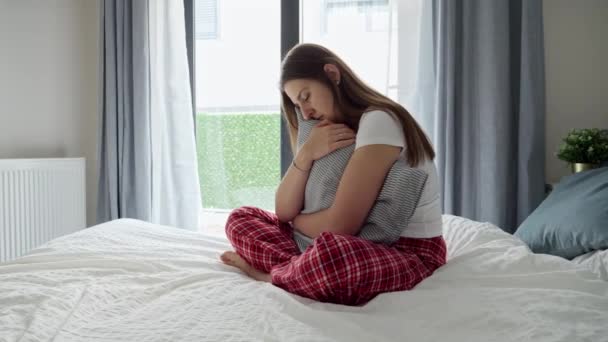 若い女性の目はベッドの上で泣きながら赤く しっかりと抱きかかえている 感情的な混乱 悲しみ 癒しの概念 — ストック動画