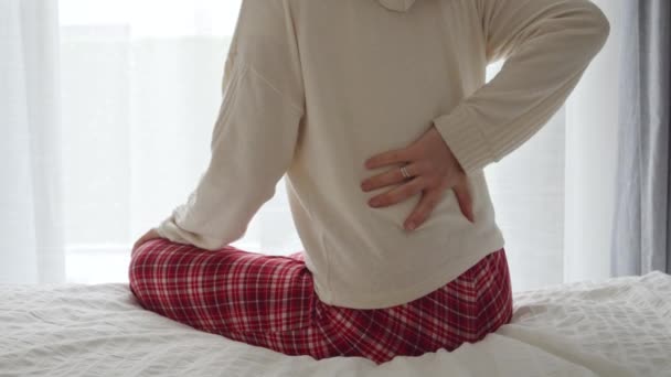 Młoda Kobieta Piżamie Siedząca Łóżku Trzymająca Bólem Plecach Pojęcie Problemów — Wideo stockowe