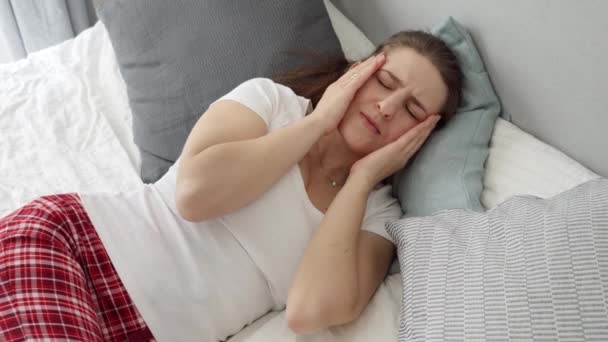 穿着睡衣的年轻女人因偏头痛而按摩她的太阳穴 医疗问题 止痛和宿醉的概念 — 图库视频影像