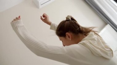 Pijamalı, sırtüstü düşen neşeli bir kadın. Mutluluk kavramı, evde rahatlama, rahatlama, evde eğlenme.
