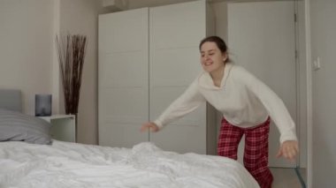 Yavaş hareket eden kadın yatağına doğru koşar ve heyecandan zıplar. Uzun bir günün ardından eve gelmenin sevinci, sıcak ve rahat bir yatağın olduğunu bilmek.