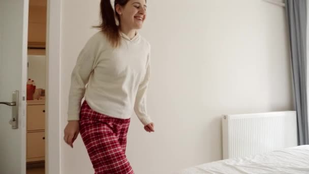 一个女人快乐地奔向她的床 跳上床 快乐地跳上床的慢镜头 在家里的那种自由和解脱的感觉 — 图库视频影像