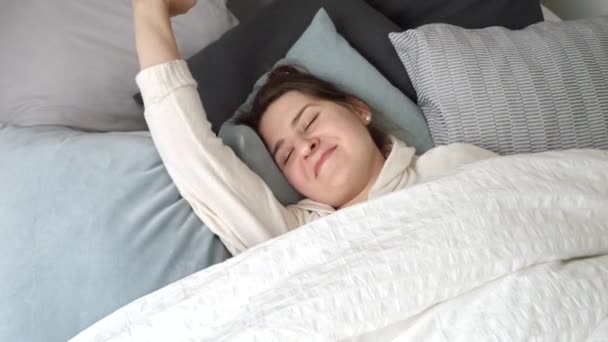 Retrato Uma Jovem Sorridente Abre Olhos Enquanto Deita Acorda Cama — Vídeo de Stock