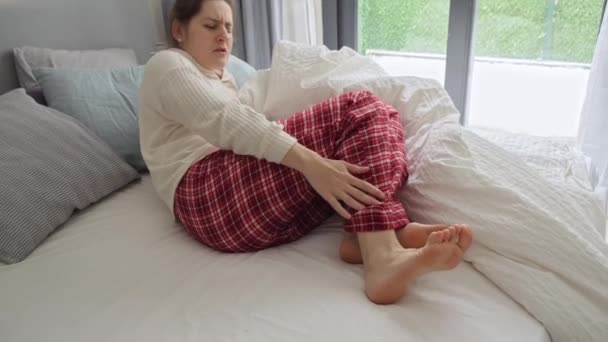 年轻女子因肌肉抽筋 腿剧痛后在床上醒来 健康问题 疼痛和创伤的概念 — 图库视频影像