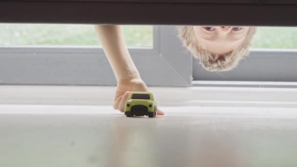 Menino Procurando Levando Seu Carro Brinquedo Perdido Debaixo Cama — Vídeo de Stock