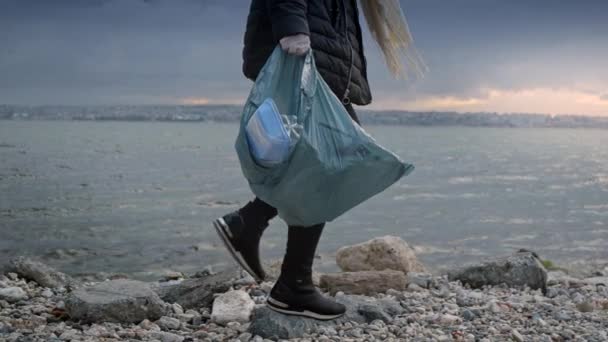 Młoda Kobieta Dobrowolnie Spaceruje Skalistym Brzegu Morza Zbiera Śmieci Gruzy — Wideo stockowe