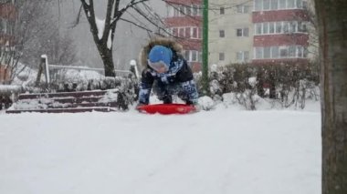 Genç bir çocuk karlı bir tepeden kayıyor, yüzü neşeyle parlıyor. Yavaş çekim etkisi merak duygusunu arttırır, hareket halindeki bir kış harikalar diyarının büyüsünü yakalar.