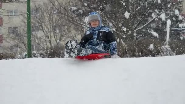 Slow Motion Cheerful Smiling Boy Riding Snowy Hill Red Plastic — Stock Video