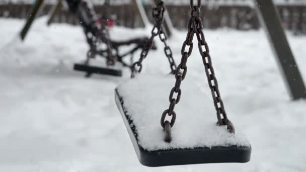 Zbliżenie Śniegu Powoli Pokrywające Puste Łańcuchy Huśtawki Zimowym Placu Zabaw — Wideo stockowe