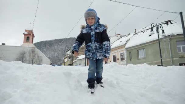 快乐的笑着男孩在街上玩着 跳着大雪漂流 快乐的婴儿 孩子们在冬天玩耍 圣诞节假期 — 图库视频影像