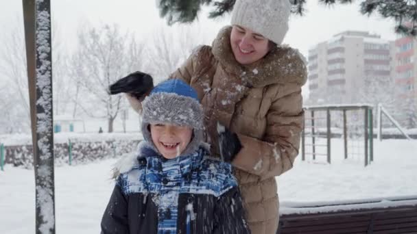 Young Mother Shaking Snow Her Son Hat Playing Winter Park — Stock Video