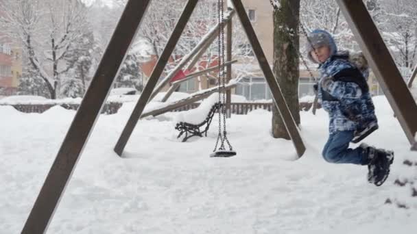 Zeitlupenaufnahmen Eines Glücklichen Kleinkindes Das Eine Schaukelfahrt Auf Einem Verschneiten — Stockvideo