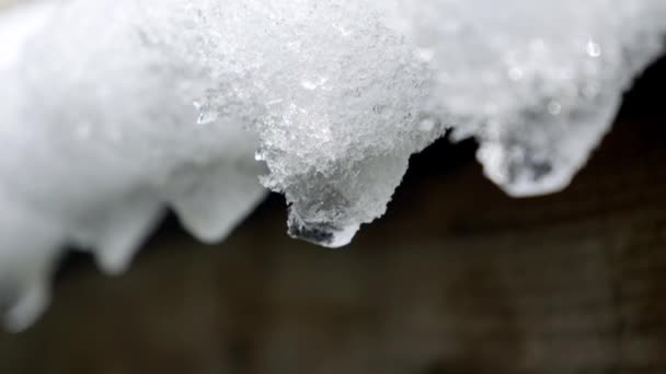Nahaufnahme Von Wassertropfen Die Von Eiszapfen Auf Ein Dach Fallen — Stockvideo
