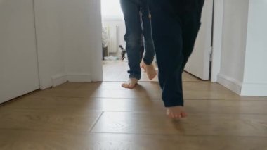 Annesi olan iki küçük çocuk, uzun bir koridorda ahşap bir zeminde ağır çekimde koşarken ve oynarken görülüyor. Çocukluğun basit zevklerini ve aktif oyunun önemini göstermek için mükemmel.