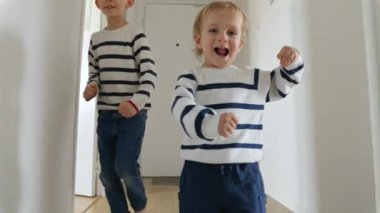 İki küçük kardeş ağır çekimde uzun tahta bir koridorda koşuyor, kahkahaları ve mutlulukları parlıyor. Oyunun önemi, aile ve çocukluğun neşesi.