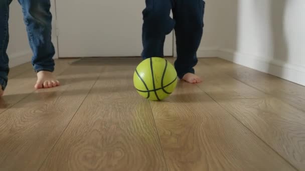 2人の幸せな子供が家の廊下の木製の床でサッカーの試合をしているのを見ることができます スローモーションは喜びと熱意 遊びと楽しみを捉えます — ストック動画