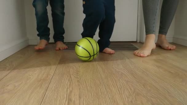 スローモーションの映像は 家の廊下の木製の床でサッカーをしている2人の若い男の子と母親を示しています ゲームへの愛 屈託のない遊び心のある性質は 子供時代の簡単な喜びを思い出させます — ストック動画