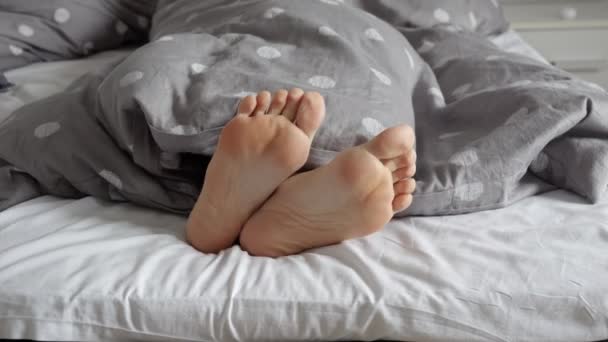 Zbliżenie Kobiecych Stóp Leżących Łóżku Pokazujących Się Spod Koca Kobieta — Wideo stockowe