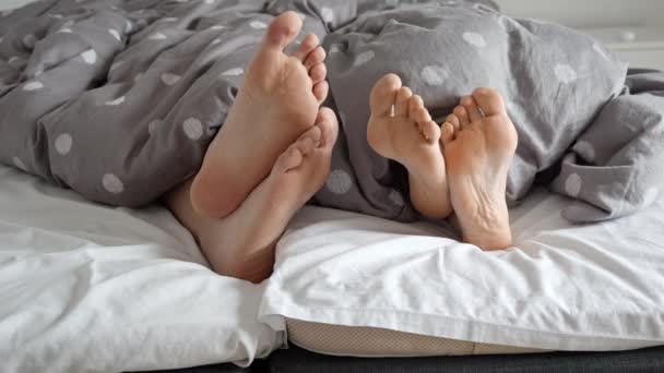 Κοντινό Πλάνο Χαρούμενα Αντρικά Και Γυναικεία Πόδια Ξαπλωμένα Μαλακό Κρεβάτι — Αρχείο Βίντεο