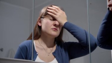 Banyo aynasına yaslanıp iç çeken üzgün kadın portresi. Depresyon, stres, zihinsel hastalık ve sorunlar, yalnızlık ve hüsran kavramı