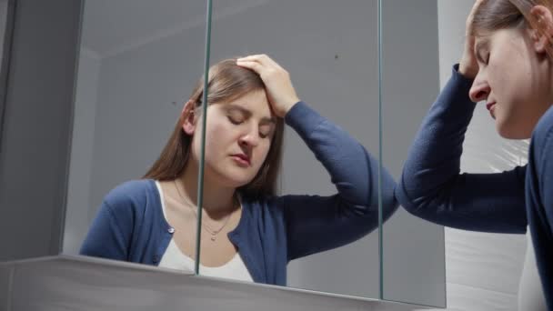 鏡に寄りかかって泣いている動揺の女性の肖像画 うつ病 ストレス 精神疾患 孤独と不満の概念 — ストック動画