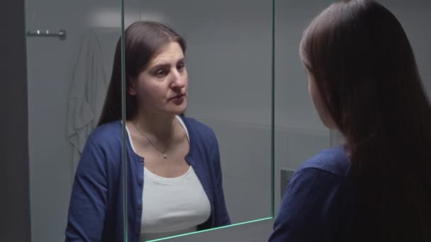 여자는 거울에 자신의 모습을 보면서 사원에서 손가락으로 자신을 척하면서 스트레스를 — 비디오