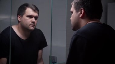 Depresyondan muzdarip genç bir adam kendini parmaklarıyla vuruyor. Depresyon, intihar, stres, akıl hastalığı, yalnızlık ve hüsran kavramı