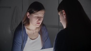 Üzgün ve yorgun bir kadın aynadaki yansımasına bakıyor. Depresyon, intihar, stres, akıl hastalığı, yalnızlık ve hüsran kavramı