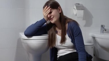 Üzgün ve üzgün kadın evdeki tuvalette yerde ağlıyor. Depresyon, intihar, stres, akıl hastalığı, yalnızlık ve hüsran kavramı