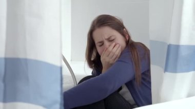 Evde banyoda oturan stresli ve korkmuş bir kadının ağlama sahnesi. Aile içi şiddet mağduru kavramı, stres, evde tehlike, korku.