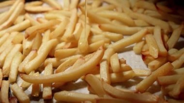Fırında kızarmış patates kızartmasının üzerine yağ dökmeye yakın. Fast food, sağlıklı beslenme, fırında pişirme.