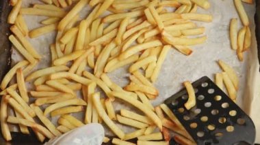 Patates kızartmasını spatulayla fırında pişiren kadının en iyi görüntüsü. Fast food, sağlıklı beslenme, fırında pişirme.