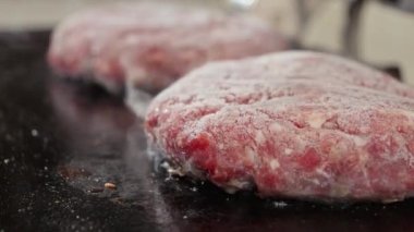 Elektrikli ızgaradaki spatulayla hamburgerleri kontrol etmeye yaklaştık. Evde yemek pişirme, mutfak aletleri, sağlıklı beslenme, hamburger malzemeleri.