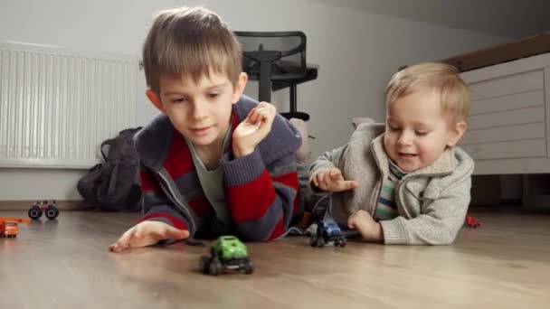 Два Мальчика Лежат Деревянном Полу Участвуют Гонке Игрушечных Машин Дети — стоковое видео