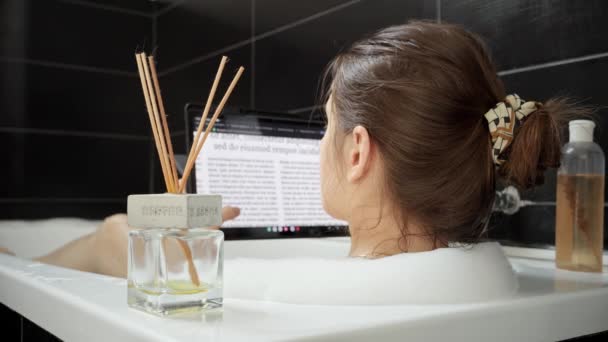一个女人洗了个舒服的澡 在她的平板电脑上冲浪 — 图库视频影像