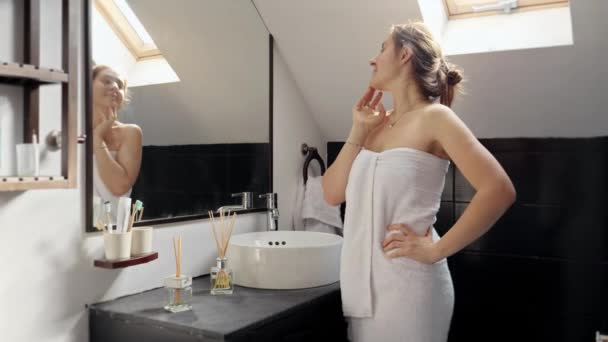 女人裹着毛巾 站在浴池里 看着镜子里的自己 妇女卫生和保健的重要性 — 图库视频影像