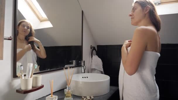 Kobieta Długimi Włosami Stojąca Wannie Pokryta Ręcznikiem Patrząca Siebie Lustrze — Wideo stockowe