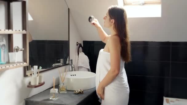 女人裹着毛巾 站在浴室里 在镜子前照顾着她的长发 女性卫生和自我护理常规 — 图库视频影像