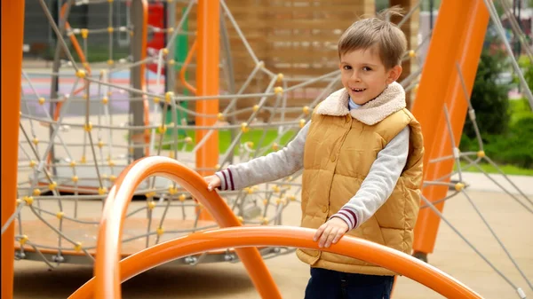 公共の遊び場でメリーゴーランドのカルーセルに回転する幸せな笑顔の少年のスローモーション アクティブな子供 スポーツや開発 屋外で遊んでいる子供たち — ストック写真