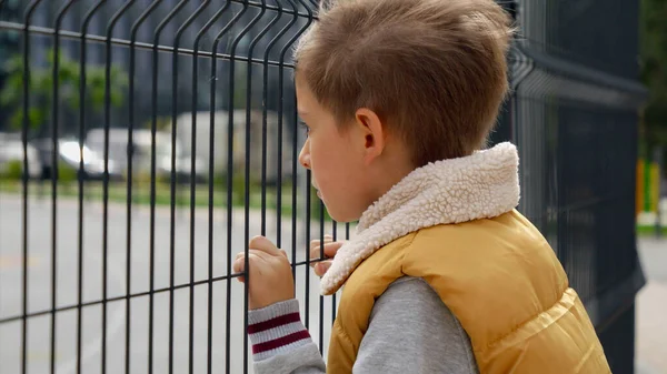 Portrait Upset Little Boy Feeling Alone Looking Metal Fence Child — Stock Photo, Image