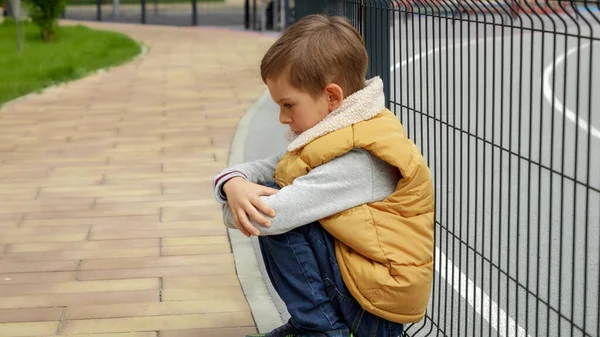 Unhappy Lonely Boy Leaning Metal Fence School Playground Sitting Child — Stock Photo, Image