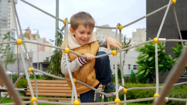 Wesoły Chłopak Wspinający Się Linach Sieciach Publicznym Placu Zabaw Aktywne — Zdjęcie stockowe